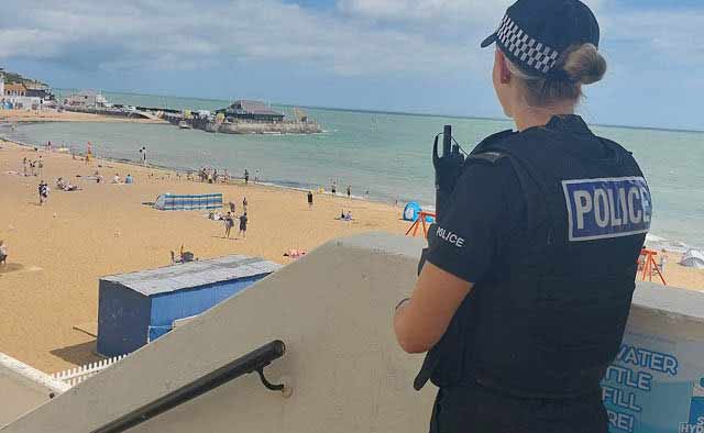 Police officer overlooking a beach.