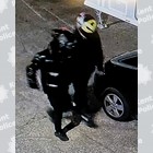 Two suspects wearing black clothing, one with a black crash helmet and one with a yellow helmet