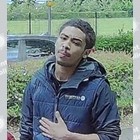 Two images of a black male with short dark  hair wearing a blue top.