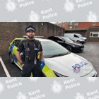 A police officer standing in front of a police car