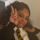 A girl making a peace sign at the camera