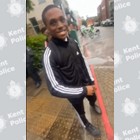 A teenager smiling at the camera in a black tracksuit