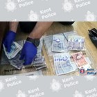 An officer counting seized cash.
