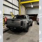 A photo of a grey/silver truck inside a yard